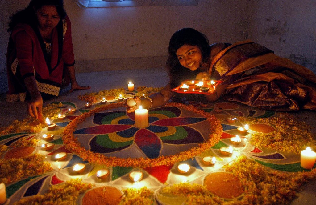 Kolkata: A girl makes a Rangoli ahead of Diwali in Kolkata, on Oct.21, 2014. (Photo: Kuntal Chakrabarty/IANS)